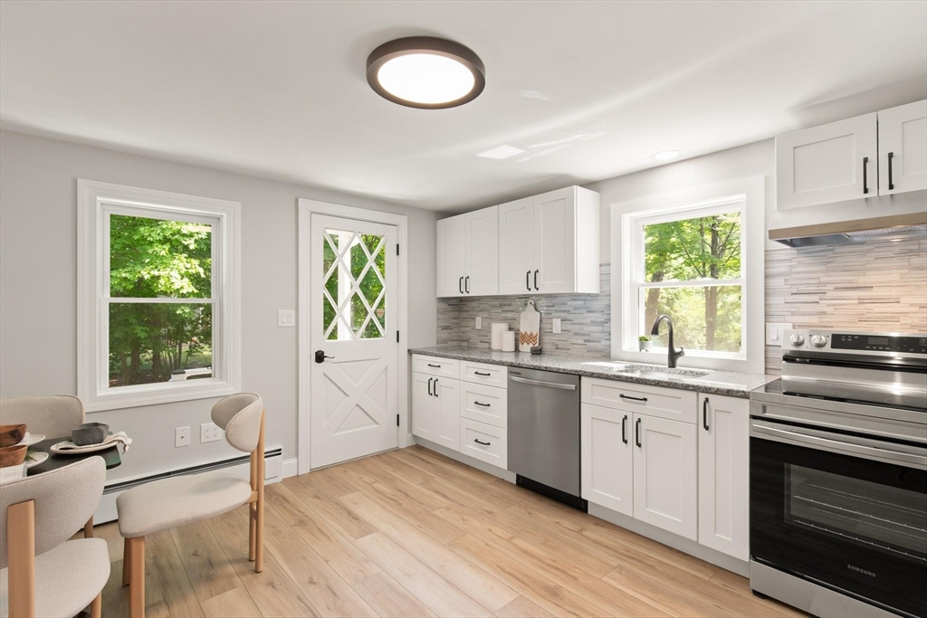 1049 Pleasant Street Canton, MA 02021 - Photo 5 of 16 a kitchen with white cabinets appliances and a window