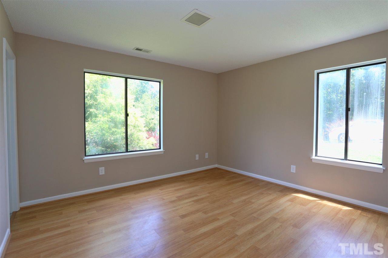 6813 Chamonix Place Raleigh, NC 27613 - Photo 14 of 25 a view of an empty room with wooden floor and a window