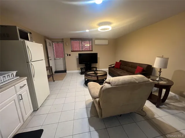 a bedroom with a bed and a refrigerator