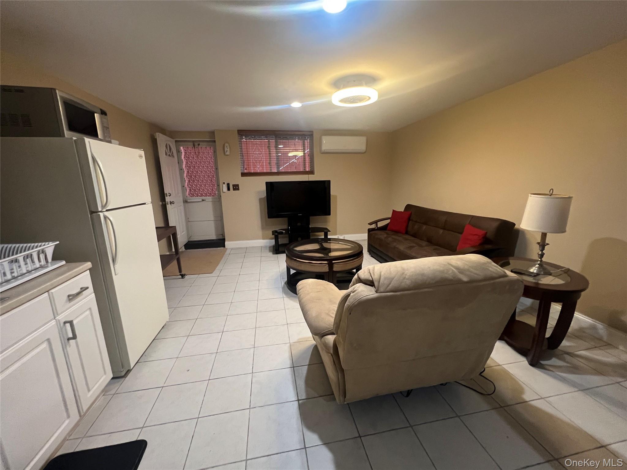 125-09 84th Road, Unit LL Queens, NY 11432 - Photo 1 of 7 a bedroom with a bed and a refrigerator