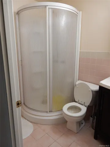 a white toilet sitting next to a shower