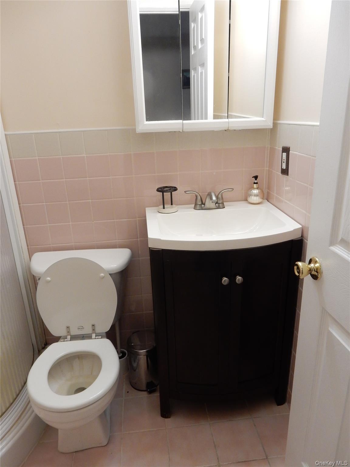 125-09 84th Road, Unit LL Queens, NY 11432 - Photo 4 of 7 a bathroom with a sink toilet and mirror
