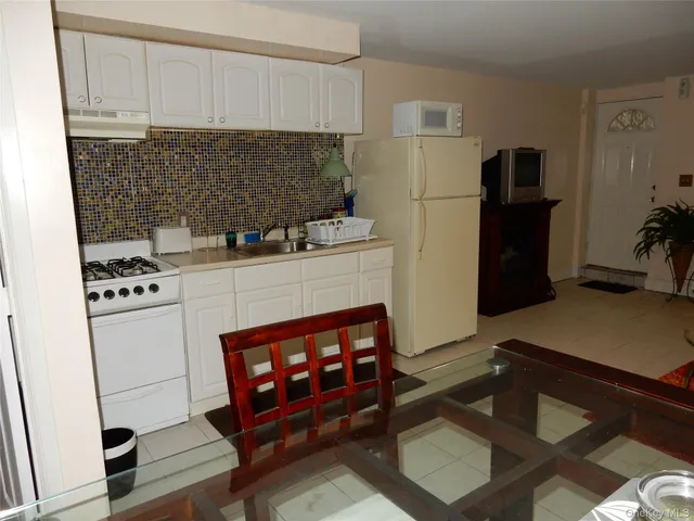 a kitchen with stainless steel appliances a stove refrigerator and cabinets