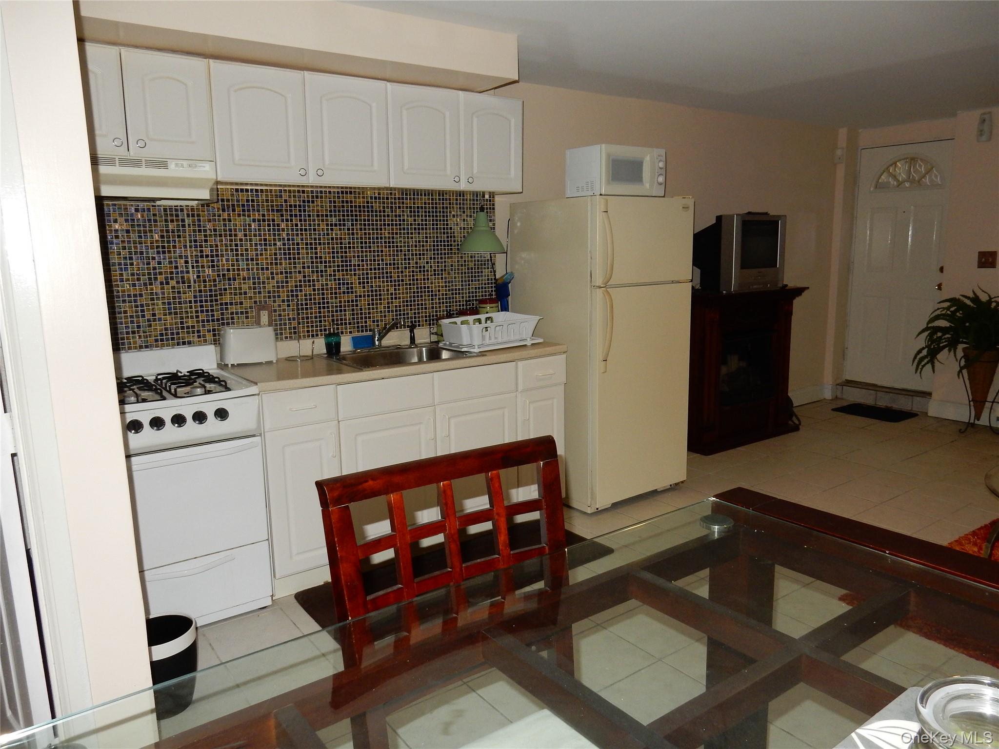 125-09 84th Road, Unit LL Queens, NY 11432 - Photo 6 of 7 a kitchen with stainless steel appliances a stove refrigerator and cabinets
