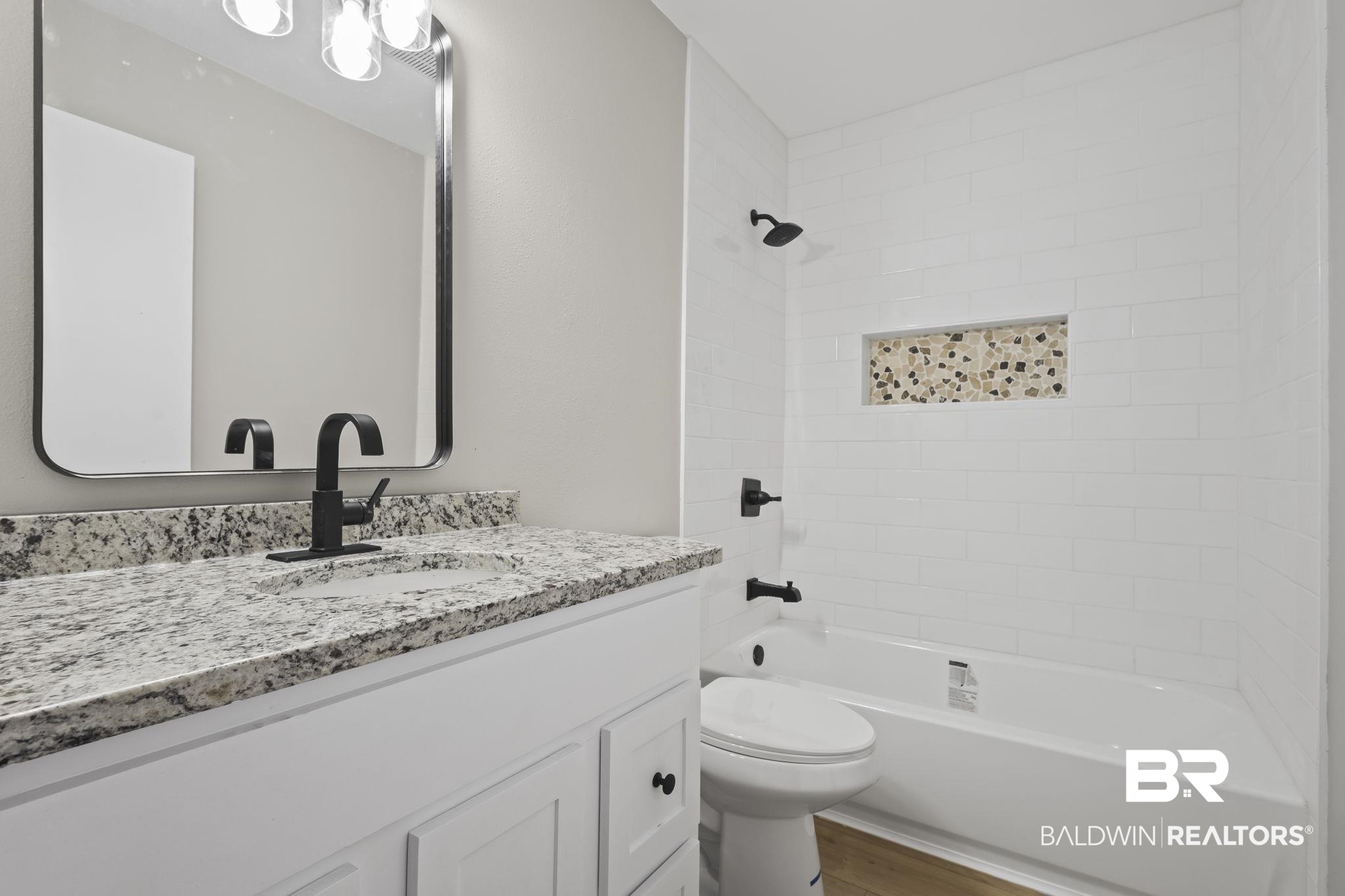 309 West Roosevelt Avenue Foley, AL 36535 - Photo 31 of 60 Full bathroom featuring wood-type flooring, vanity, toilet, and tiled shower / bath combo