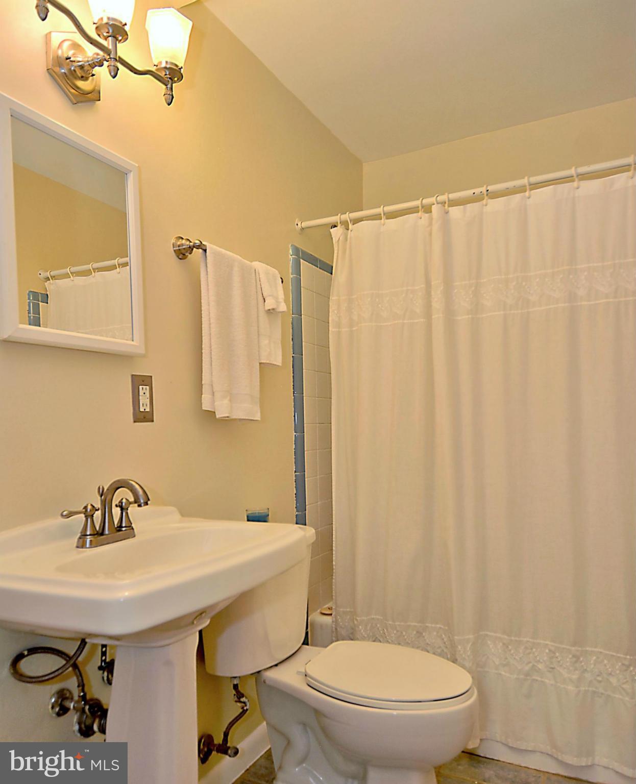 209 MacArthur Road Alexandria, VA 22305 - Photo 21 of 26 a bathroom with a sink a toilet and shower curtain