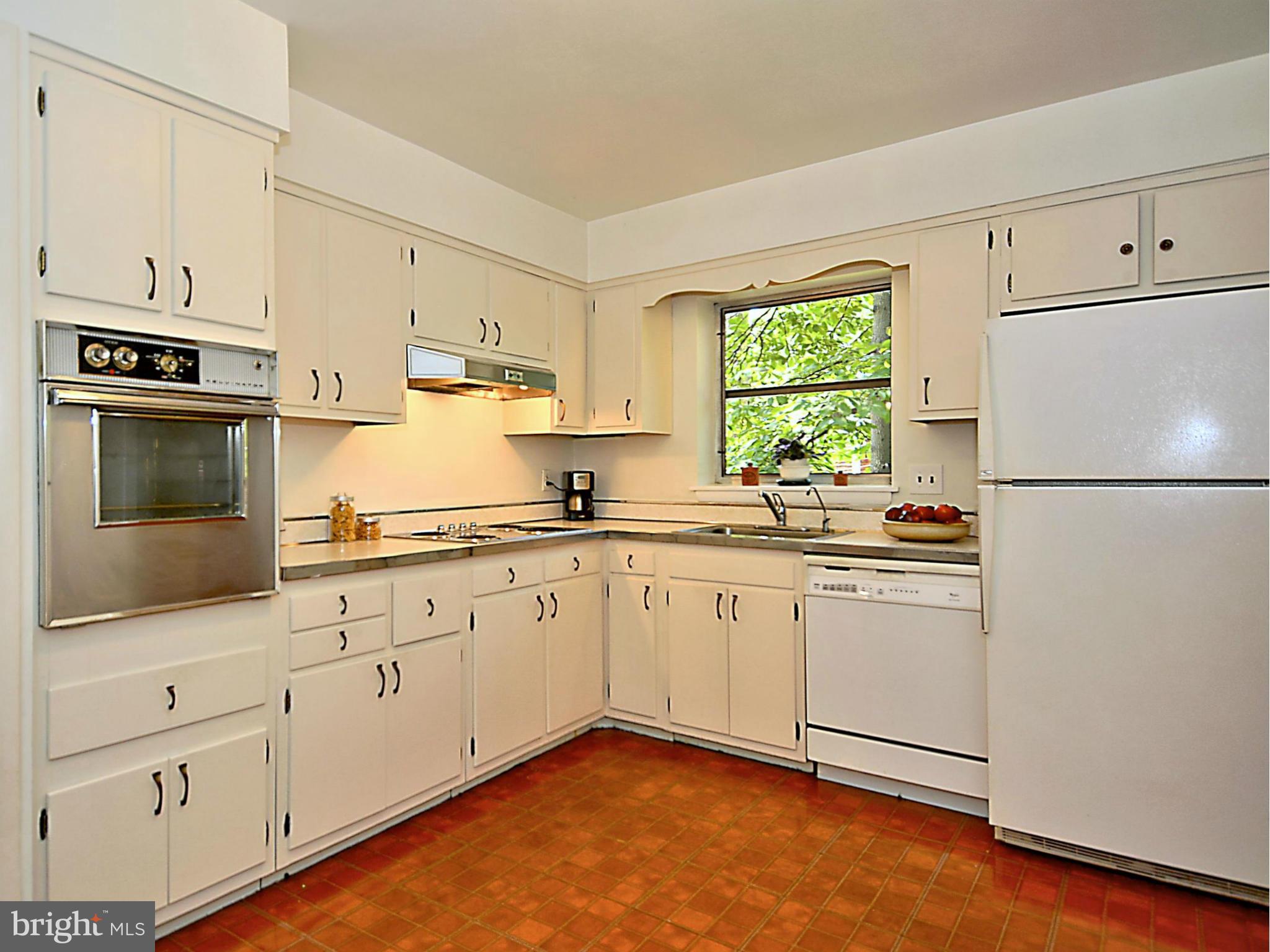 209 MacArthur Road Alexandria, VA 22305 - Photo 7 of 26 a kitchen with granite countertop white cabinets white appliances a sink and a window