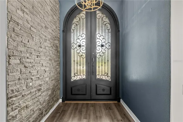 a view of a hallway with wooden floor and a chandelier