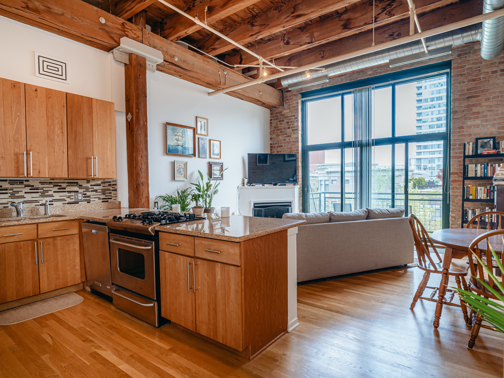 1727 South Indiana Avenue, Unit 324 Chicago, IL 60616 - Photo 5 of 35 a kitchen with kitchen island granite countertop wooden floors and stainless steel appliances