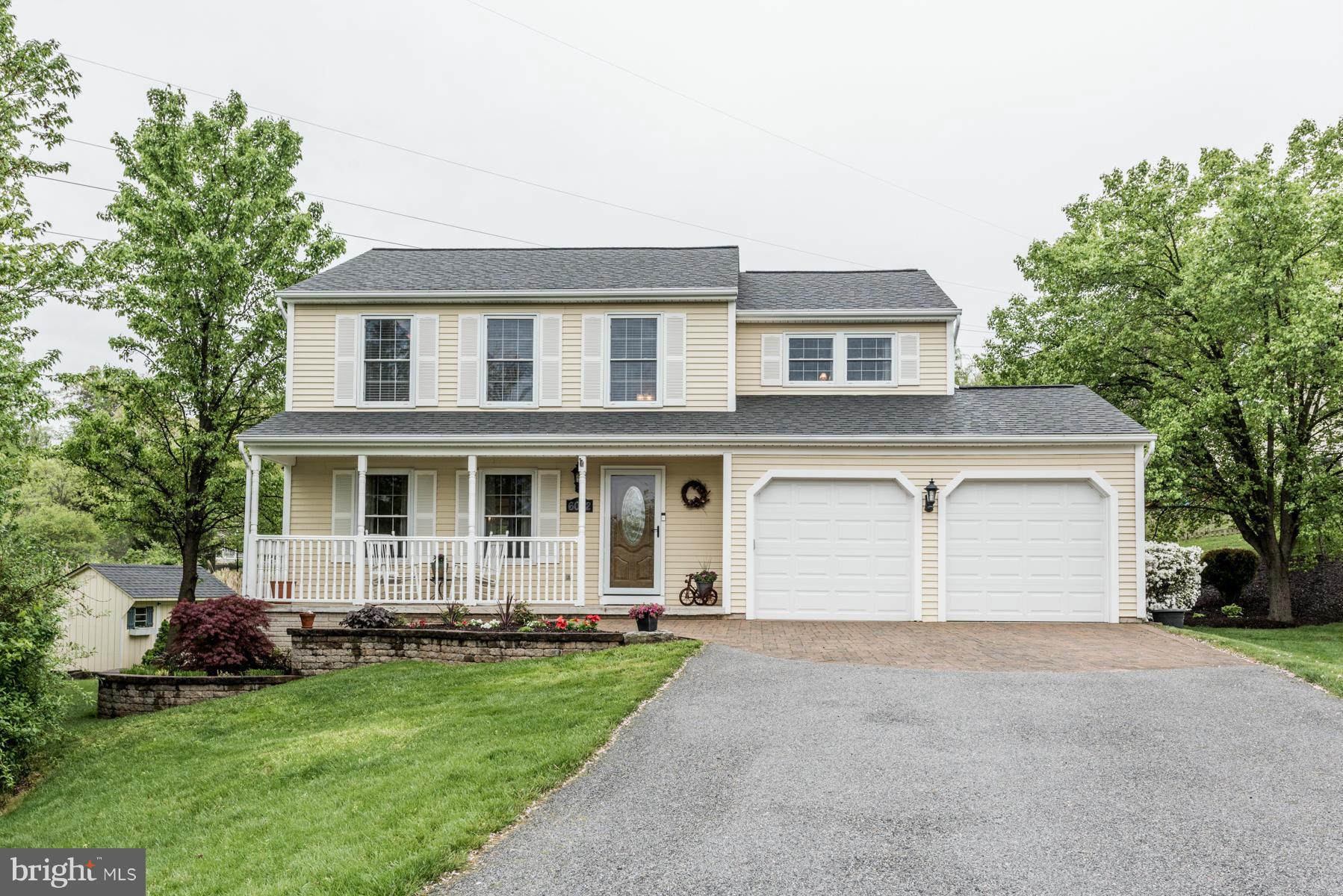 a front view of a house with a garden and yard