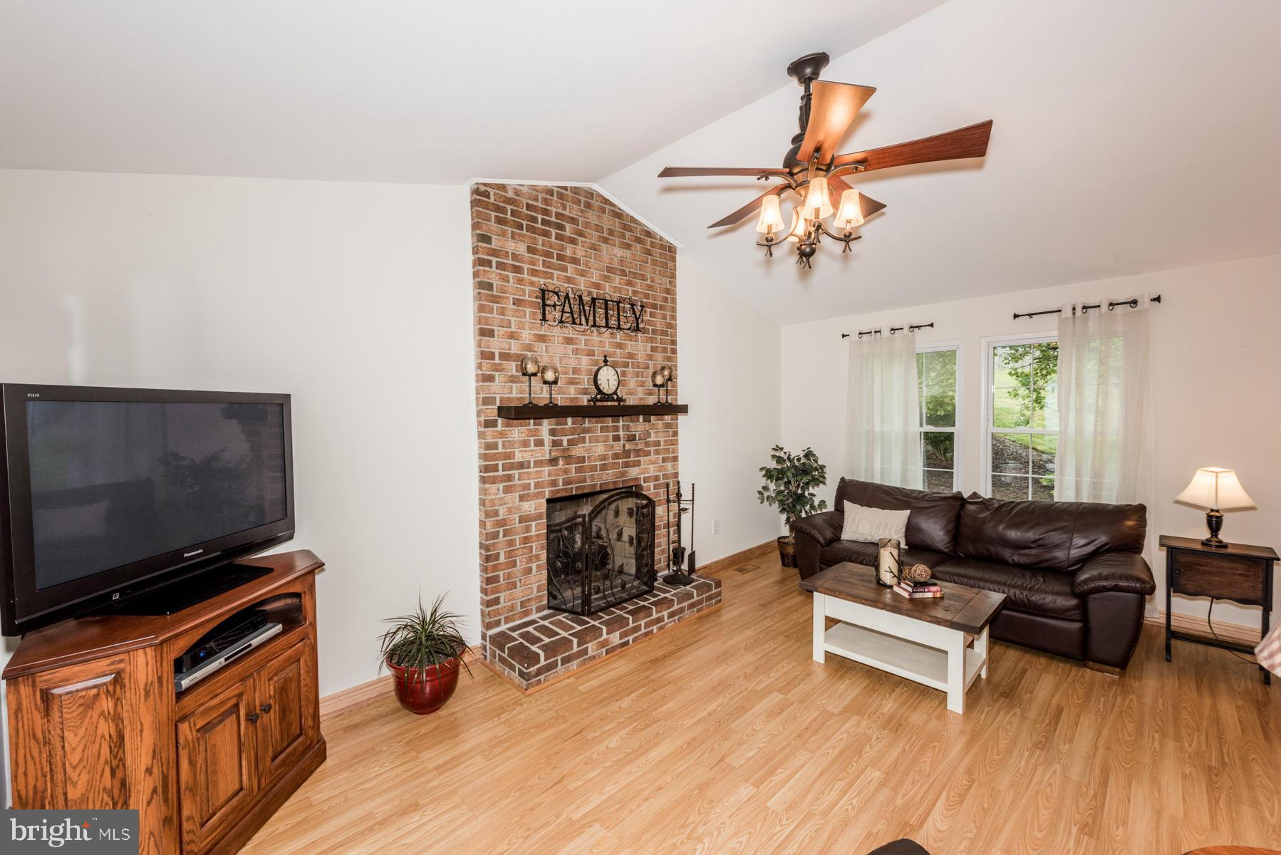 6032 Bakers Place Hanover, MD 21076 - Photo 12 of 30 a living room with furniture a flat screen tv and a fireplace
