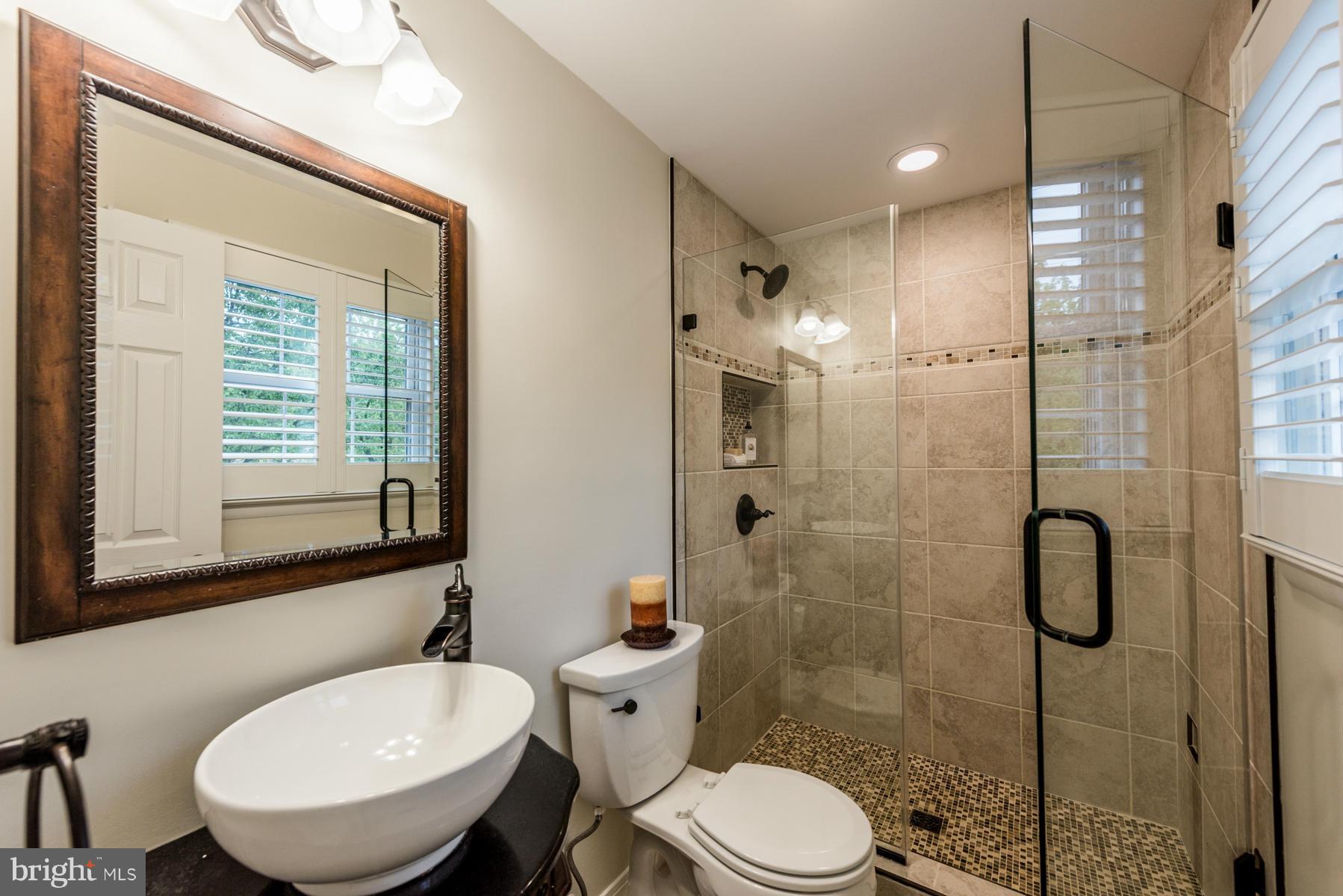 6032 Bakers Place Hanover, MD 21076 - Photo 18 of 30 a bathroom with a sink toilet a mirror and shower