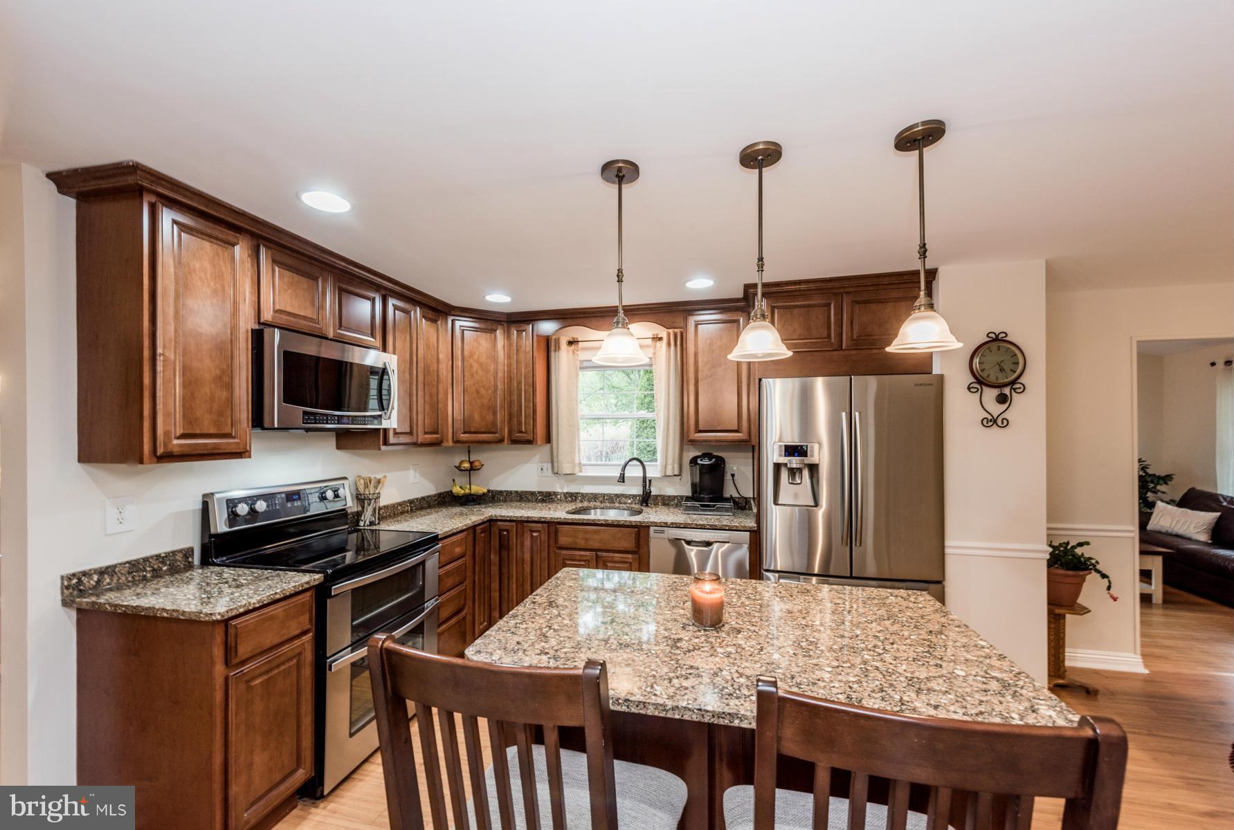 6032 Bakers Place Hanover, MD 21076 - Photo 3 of 30 a kitchen with stainless steel appliances granite countertop a stove refrigerator sink and cabinets