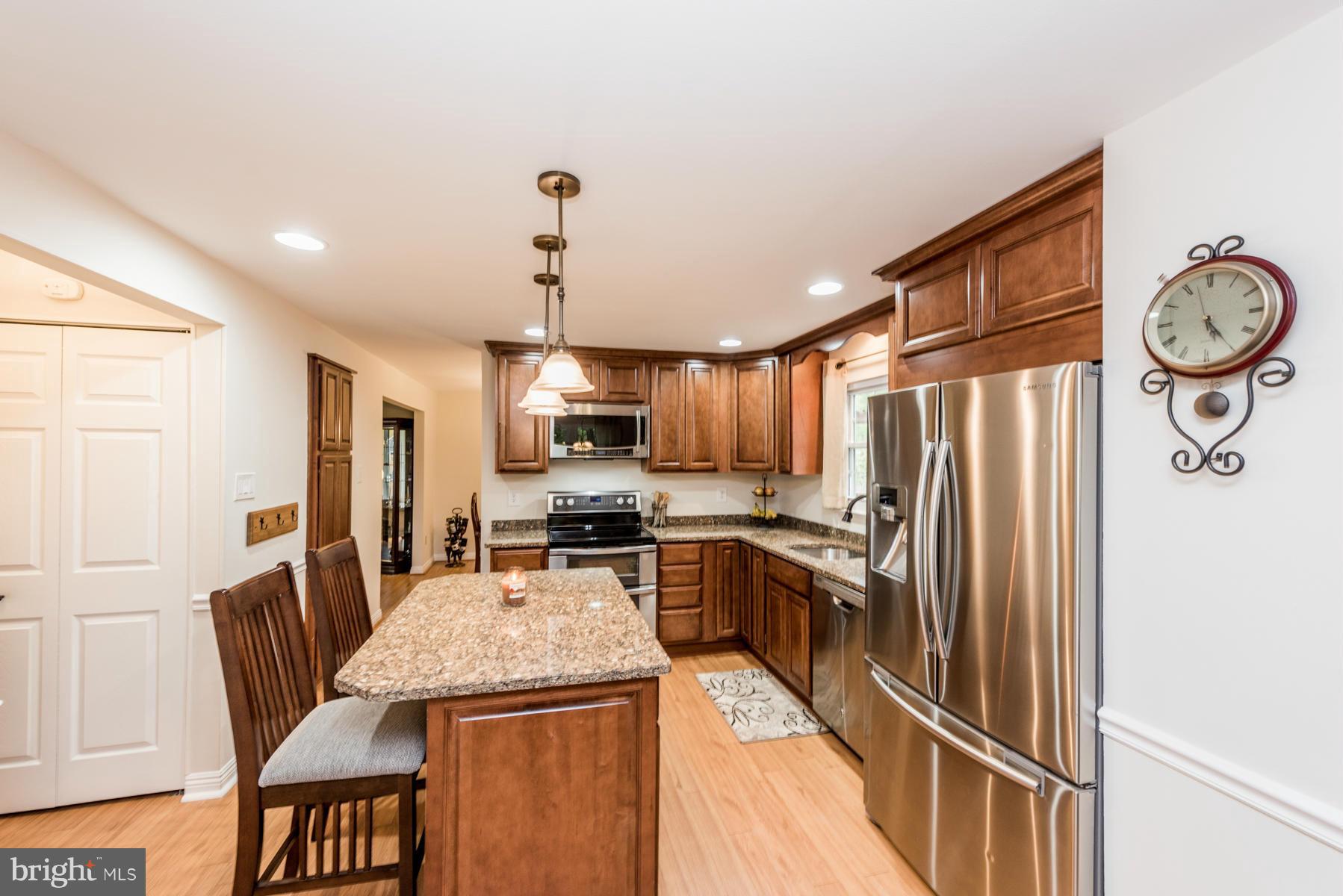 6032 Bakers Place Hanover, MD 21076 - Photo 4 of 30 a kitchen with stainless steel appliances granite countertop a refrigerator a stove top oven a sink dishwasher and white cabinets
