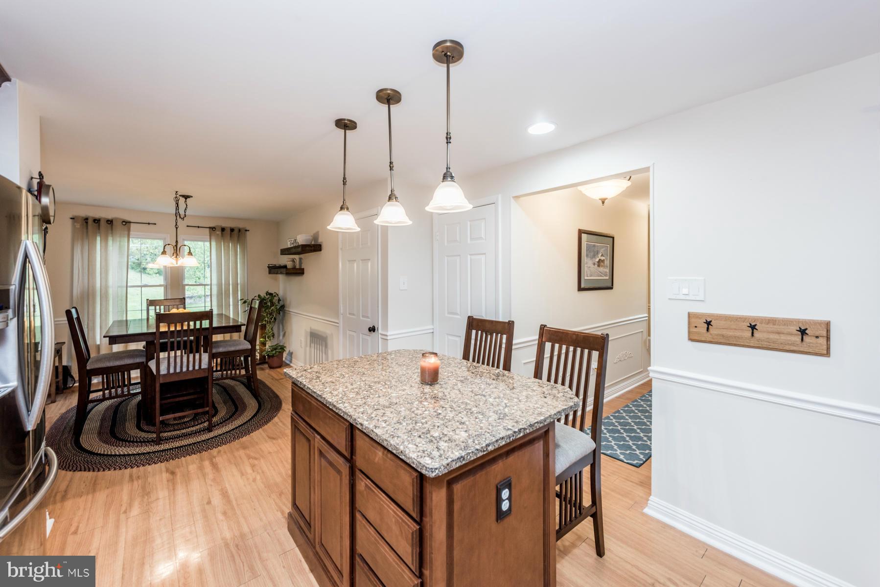 6032 Bakers Place Hanover, MD 21076 - Photo 5 of 30 a kitchen with a table chairs and white cabinets