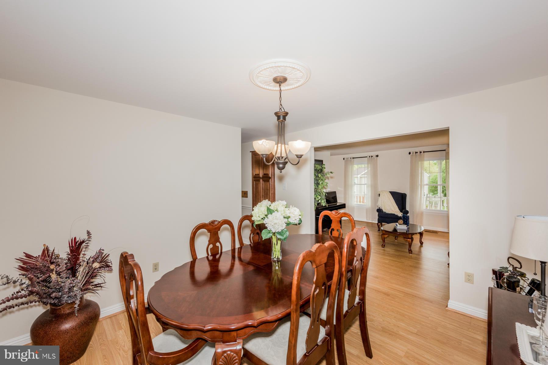 6032 Bakers Place Hanover, MD 21076 - Photo 9 of 30 a dining room with furniture potted plants and wooden floor