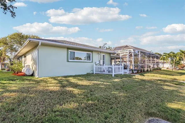 a view of a house with a big yard and large trees