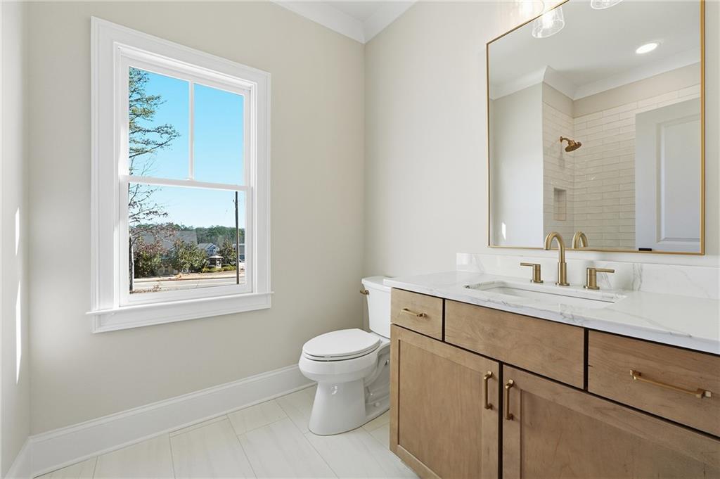 280 County Road Southwest Marietta, GA 30064 - Photo 29 of 40 a bathroom with a granite countertop toilet a sink a mirror and a window