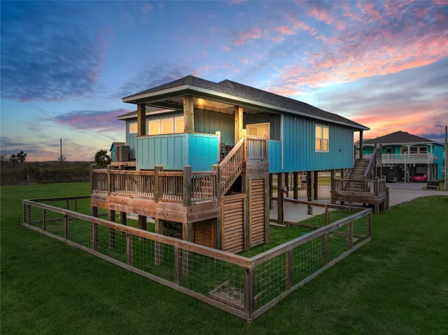 a front view of house along with deck and outdoor seating
