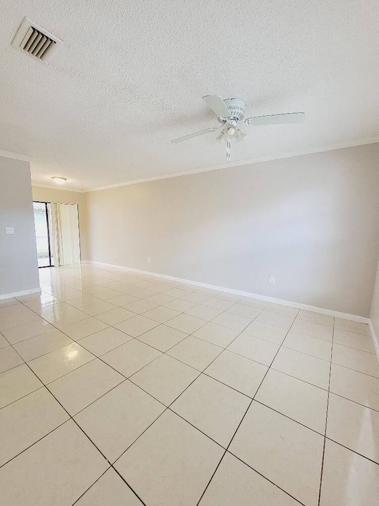 12785 Peconic Court, Unit 12785 Wellington, FL 33414 - Photo 11 of 12 an empty room with chandelier fan and windows