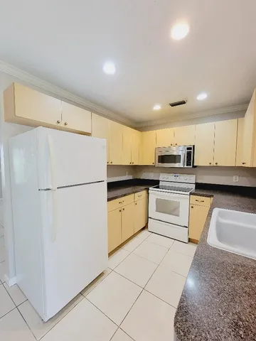a kitchen with white cabinets and white appliances