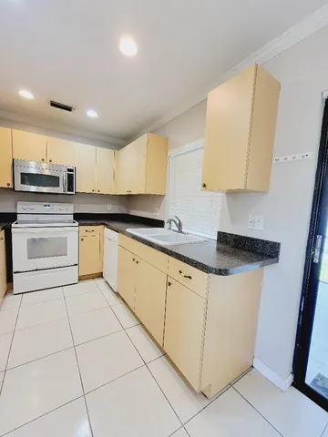 a kitchen with stainless steel appliances granite countertop a sink and a stove
