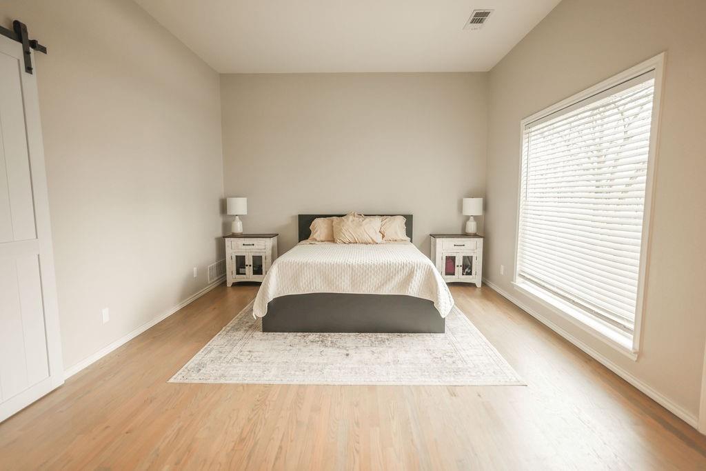 9501 Oakwood Road Quinlan, TX 75474 - Photo 12 of 34 a large bed sitting in a bedroom next to a window