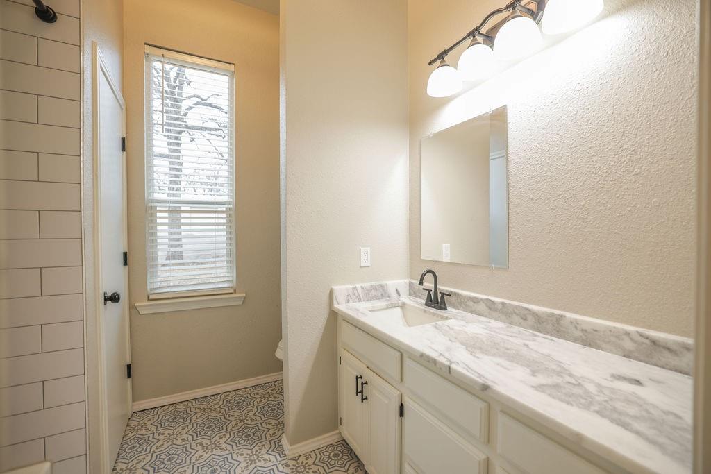 9501 Oakwood Road Quinlan, TX 75474 - Photo 14 of 34 a bathroom with a granite countertop sink and a mirror