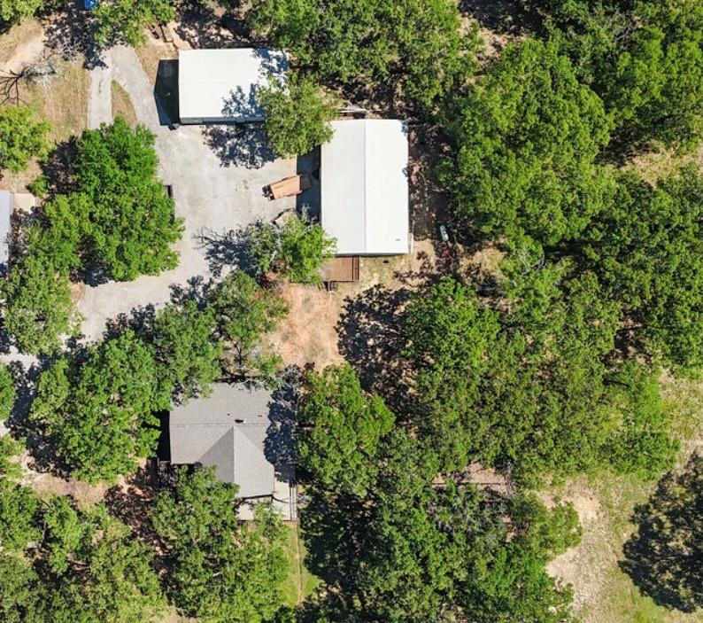 9501 Oakwood Road Quinlan, TX 75474 - Photo 4 of 34 an aerial view of a house with a yard and trees all around