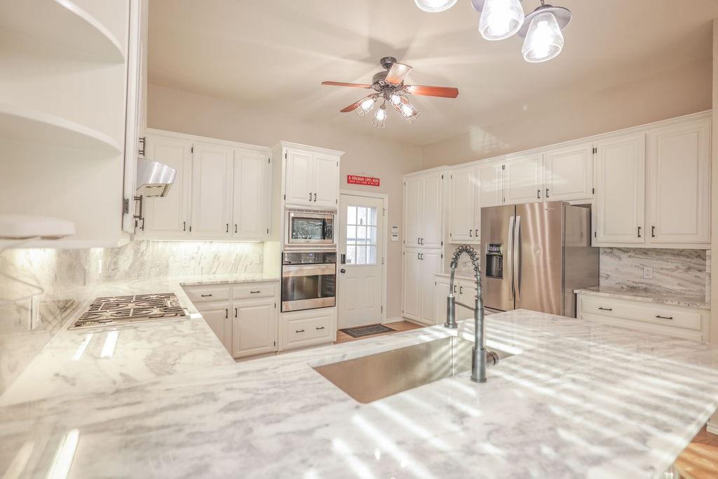 9501 Oakwood Road Quinlan, TX 75474 - Photo 5 of 34 a view of a kitchen with a sink stainless steel appliances and cabinets