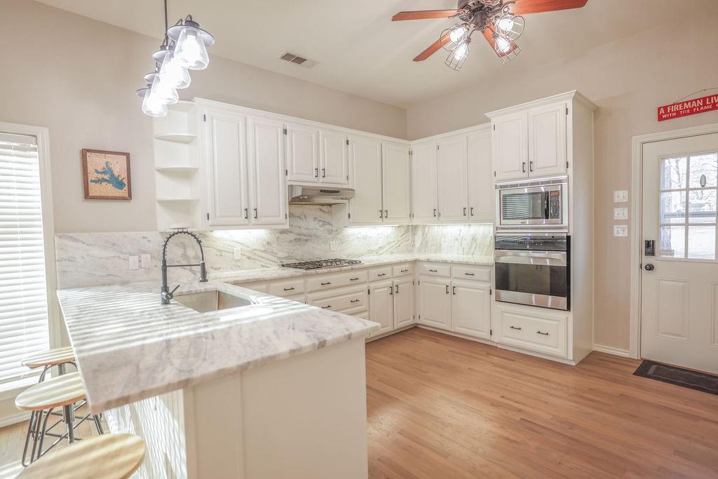 9501 Oakwood Road Quinlan, TX 75474 - Photo 6 of 34 a kitchen with granite countertop white cabinets and appliances