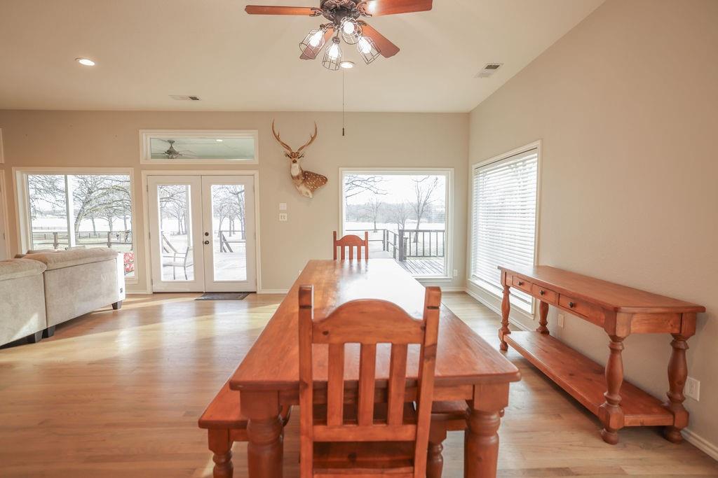 9501 Oakwood Road Quinlan, TX 75474 - Photo 7 of 34 a dining room with wooden floor a chandelier a glass table and chairs