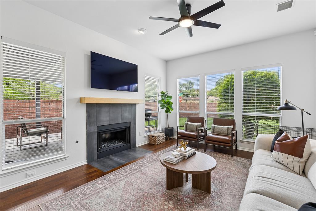 7703 Worthing Street Dallas, TX 75252 - Photo 8 of 21 a living room with furniture a flat screen tv and a fireplace