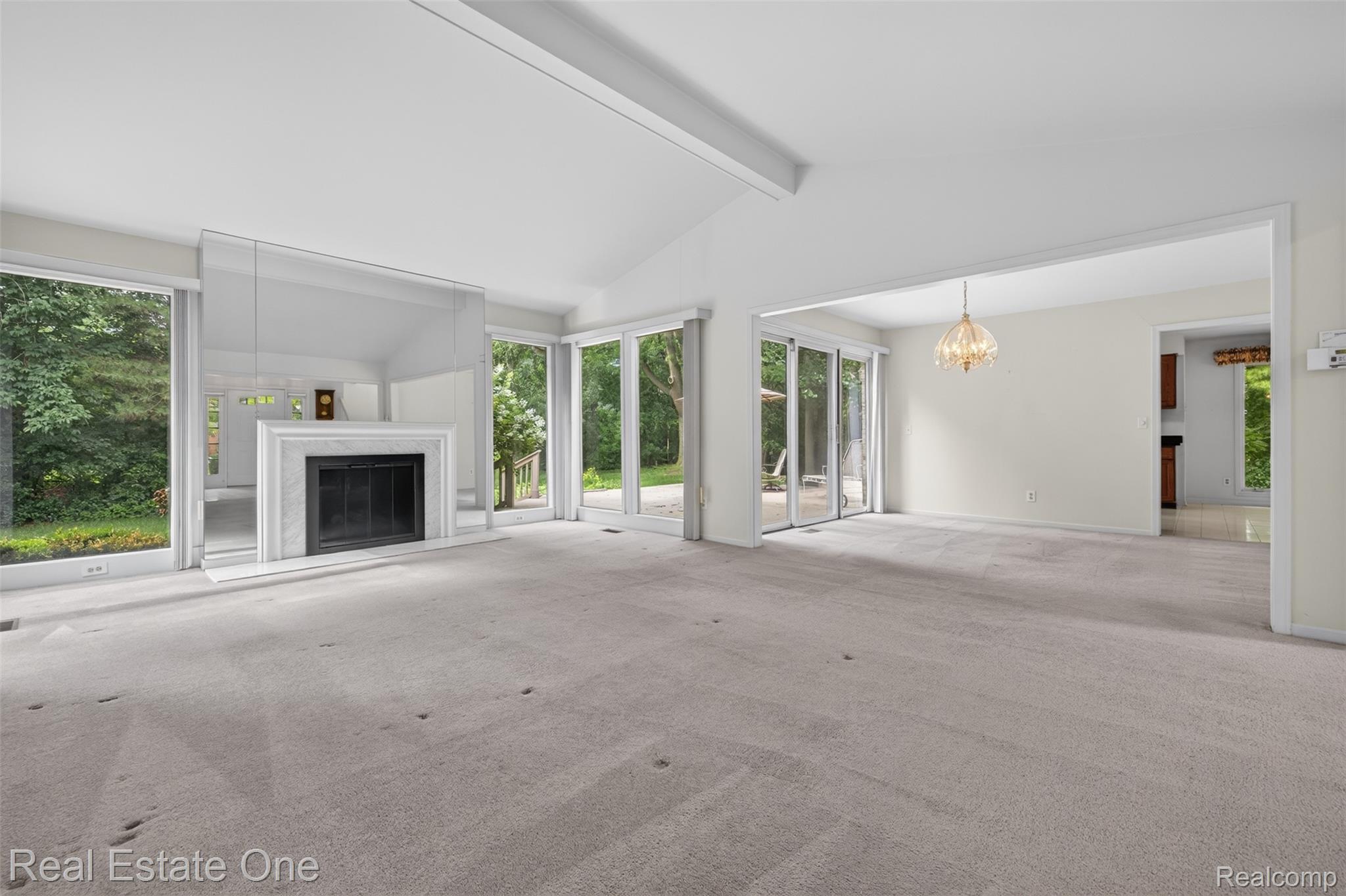 3400 Wedgewood Drive Rochester, MI 48306 - Photo 12 of 49 Spacious living area featuring a vaulted ceiling and a fireplace with a white surround