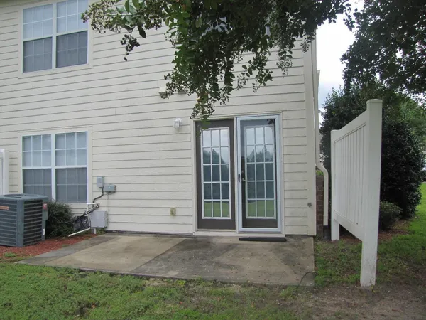 a small house with a white door and outdoor space