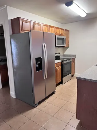 a metallic refrigerator freezer sitting in a kitchen