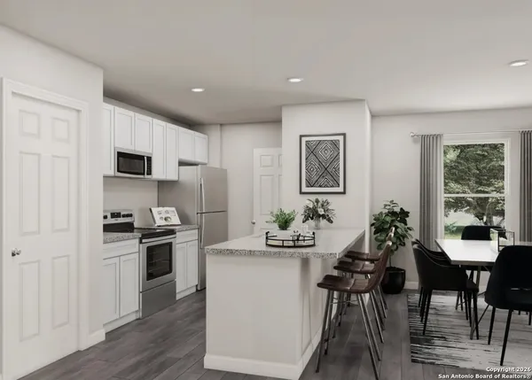 a very nice looking dining room with kitchen island furniture a large window and a wooden floor