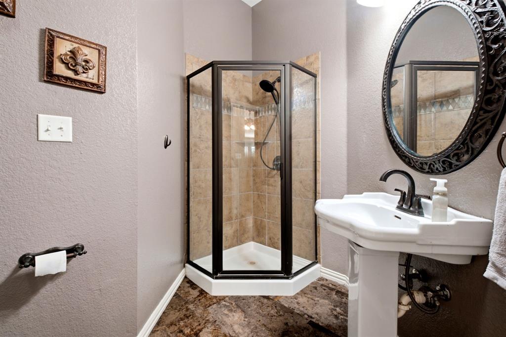 600 Aspen Street Pilot Point, TX 76258 - Photo 15 of 39 Pedestal sink with dark bronze fixtures, framed by an ornate oval mirror