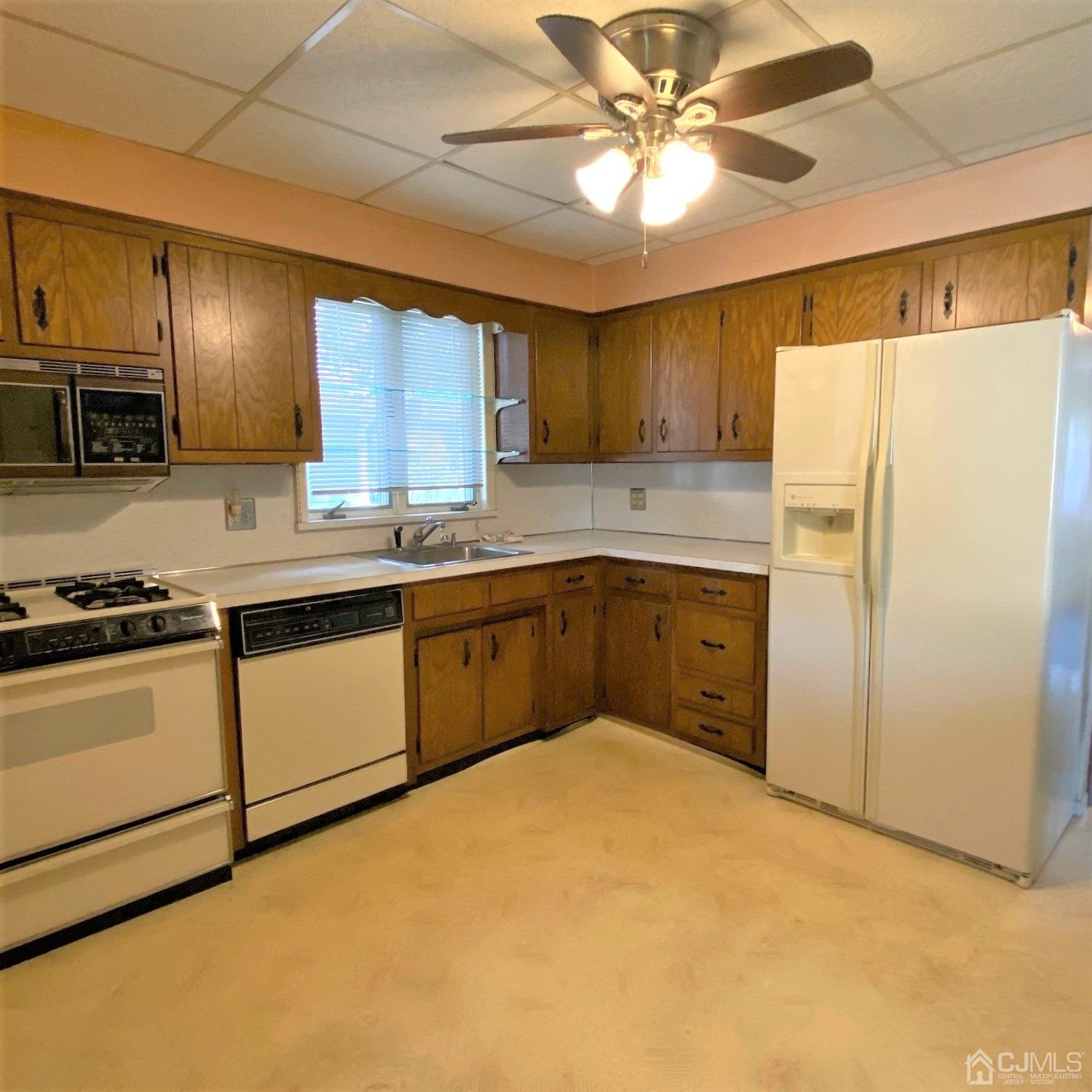712 Center Street Dunellen, NJ 08812 - Photo 16 of 24 a kitchen with a sink a stove a refrigerator and cabinets