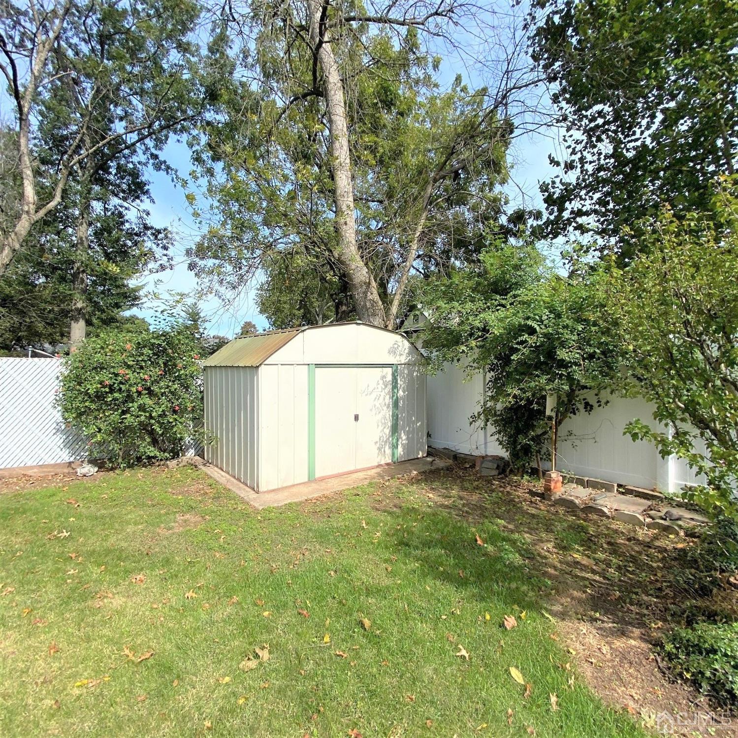 712 Center Street Dunellen, NJ 08812 - Photo 6 of 24 a view of a tiny house with a yard and large trees