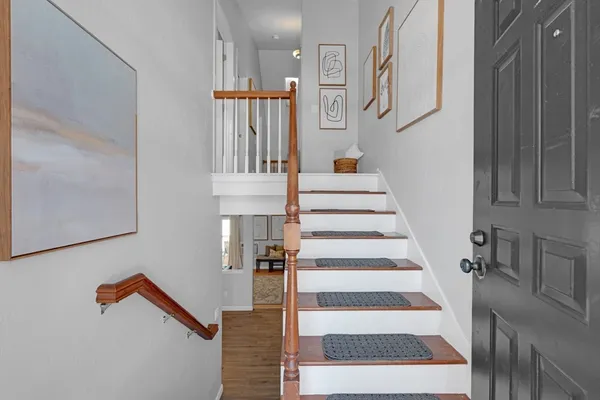 a view of staircase with white walls and a painting on the wall