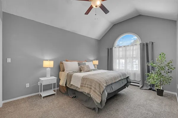 a spacious bedroom with a bed and a chandelier