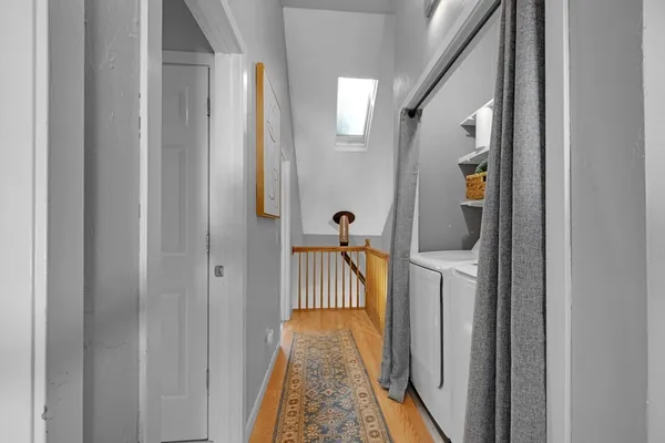 a view of a hallway with wooden floor and staircase