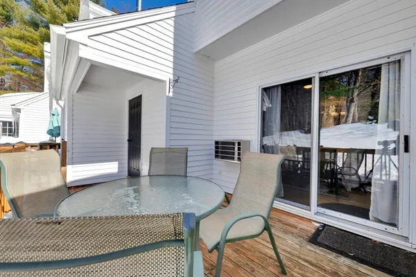 a view of a patio with table and chairs with wooden floor and fence