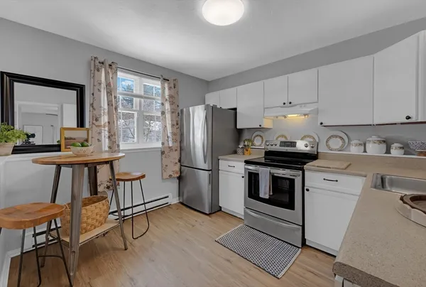 a kitchen with a refrigerator a stove a sink and dishwasher with wooden floor