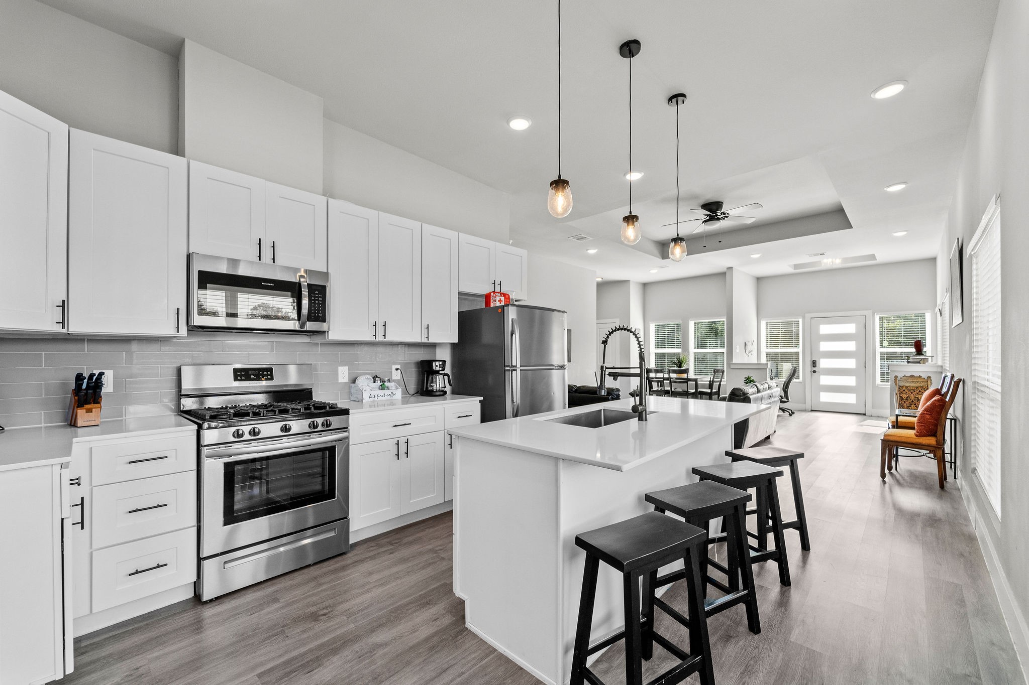507 Carl Street Houston, TX 77009 - Photo 23 of 24 a kitchen with stainless steel appliances kitchen island granite countertop a stove a sink a dining table and chairs with wooden floor