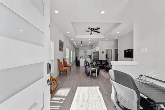 a kitchen with stainless steel appliances kitchen island granite countertop a stove a sink a dining table and chairs with wooden floor