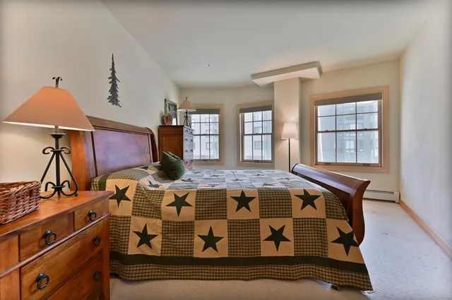 a bed sitting in a bedroom next to a window