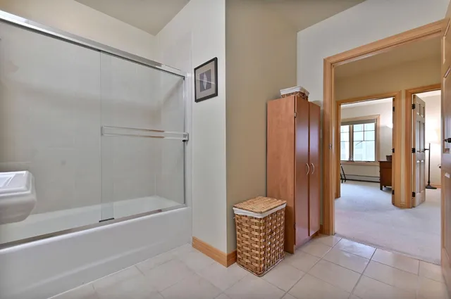 a bathroom with a tub shower and sink