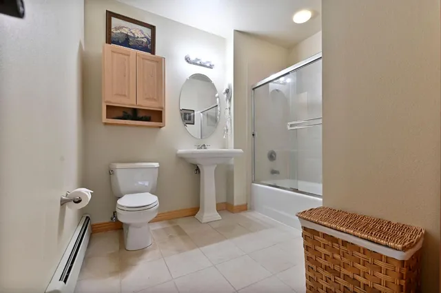 a bathroom with a toilet a sink and mirror